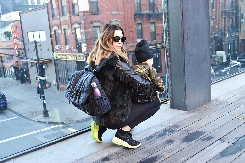 Model and author Tinamarie Clark wears her Levy Backpack Black in NYC with her son