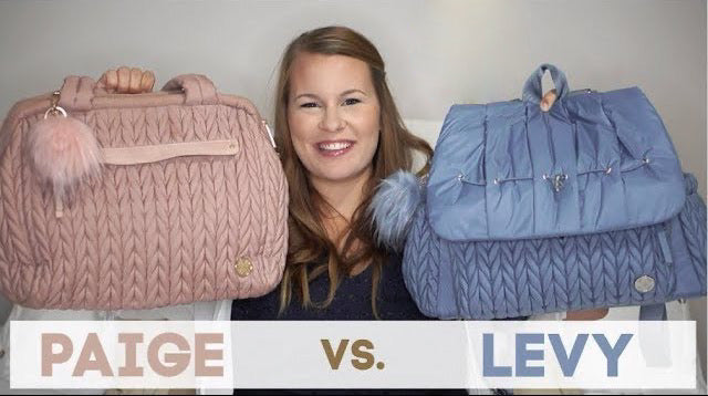 Screenshot of Paige vs. Levy comparison video. Smiling mom holding up Paige Carryall Rose and Levy Backpack Blue, front view, with matching pouf charms.