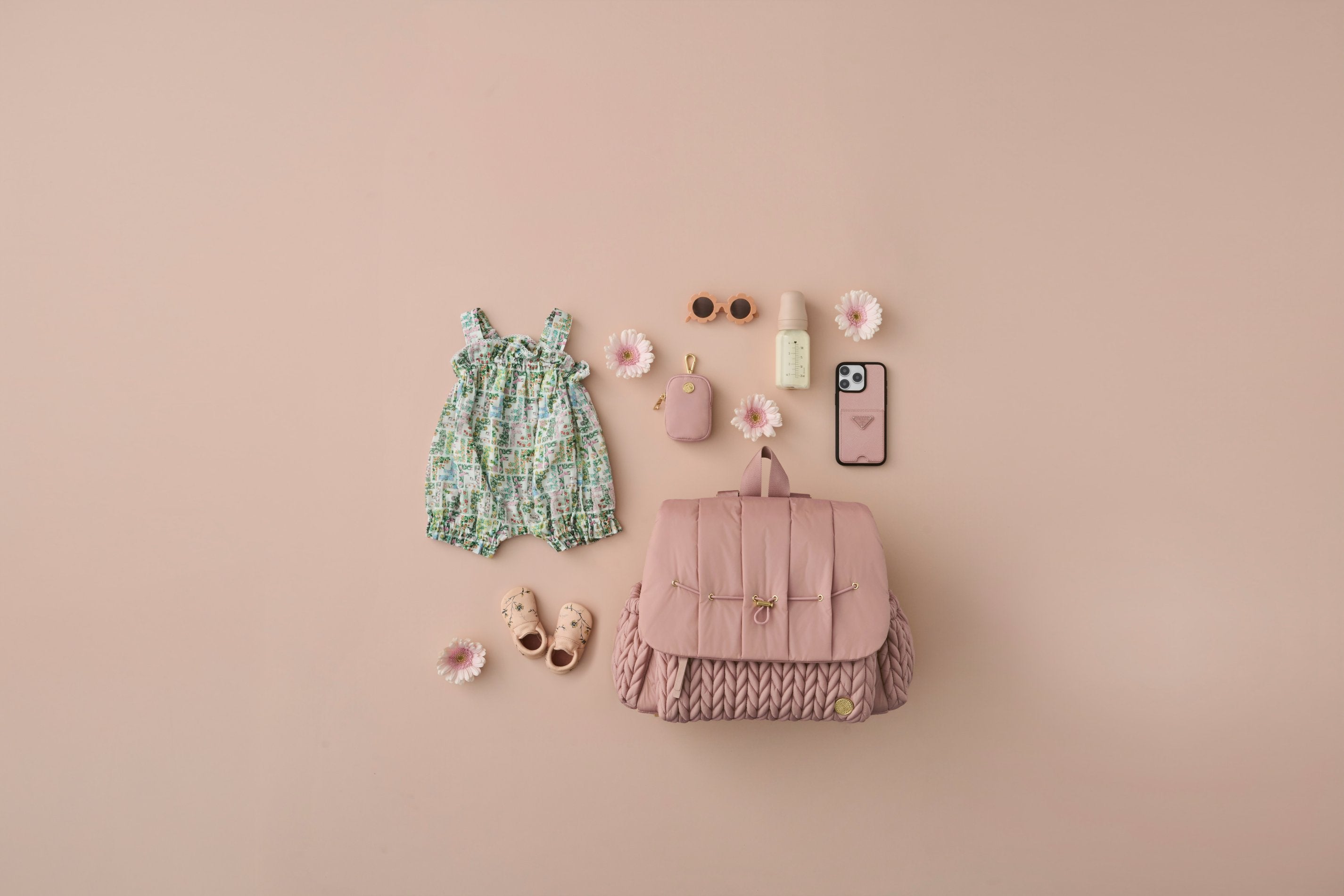 HAPP Brand Levy Backpack in Dusty Rose with matching clip-on pouch and coordinated baby and mom accessories arranged on a pink background.