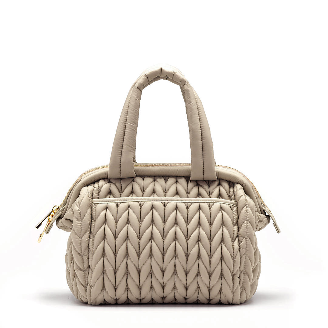 Back view of the Paige Mini Beige, showing herringbone quilting, carry handles, and back pocket with magnet closure.