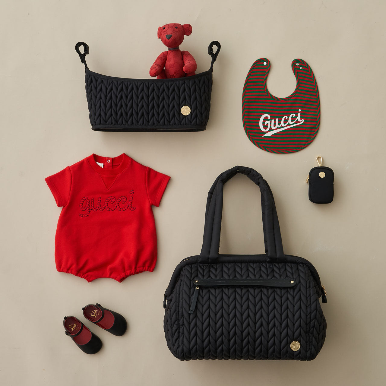 Paige Carryall Black shown with HAPP Stroller Organizer Black and Clip-on Pouch Black, arranged with red and black baby items.