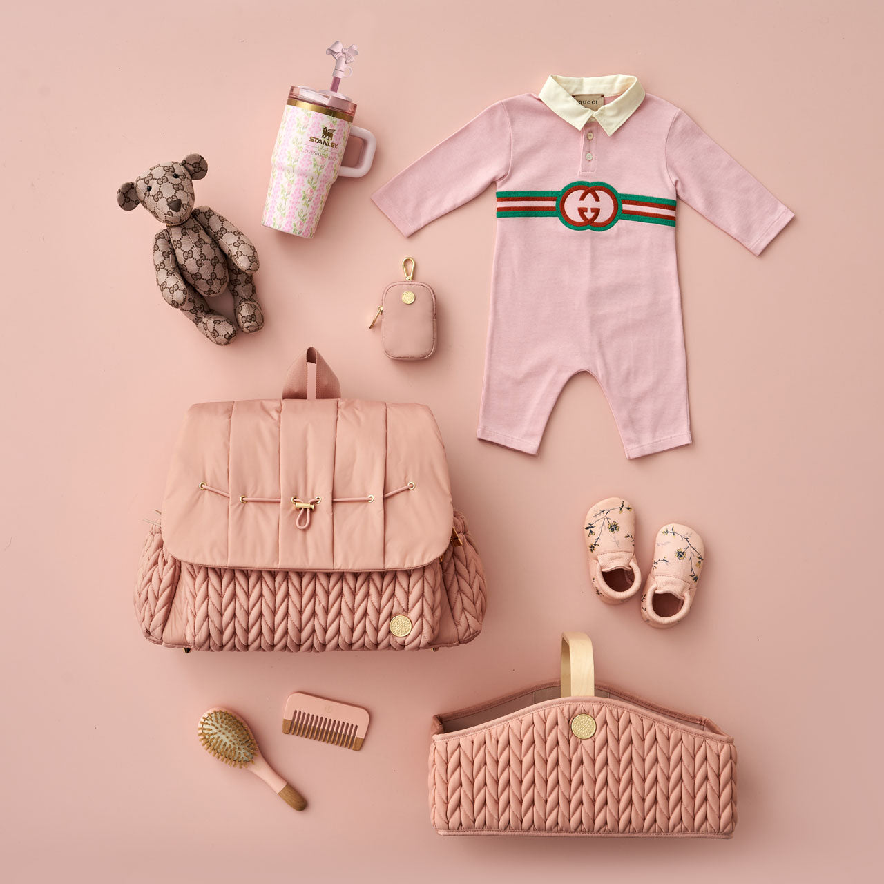 Flat lay with HAPP Levy Backpack and Diaper Caddy in matching rose, packed and surrounded by color-coordinated baby items.
