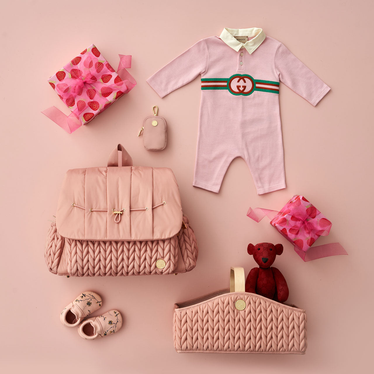 Levy Backpack Dusty Rose lying flat and closed, arranged with color-coordinated baby items and a matching Diaper Caddy Rose.