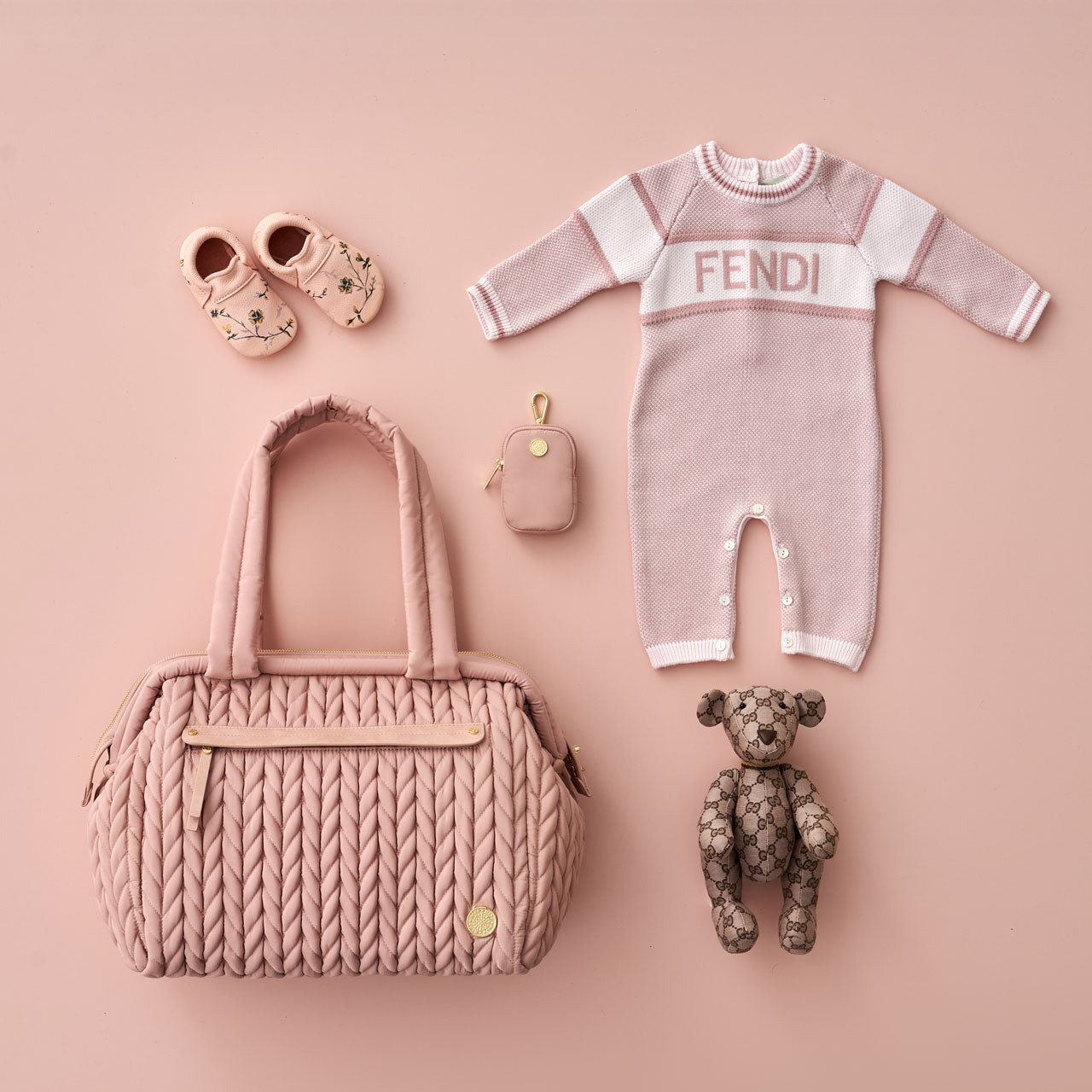 Paige Carryall in rose from the front, showing faux leather trimmed mommy pocket, herringbone quilting, and padded handles. Pictured with matching baby items and HAPP Clip-on Pouch in Rose.