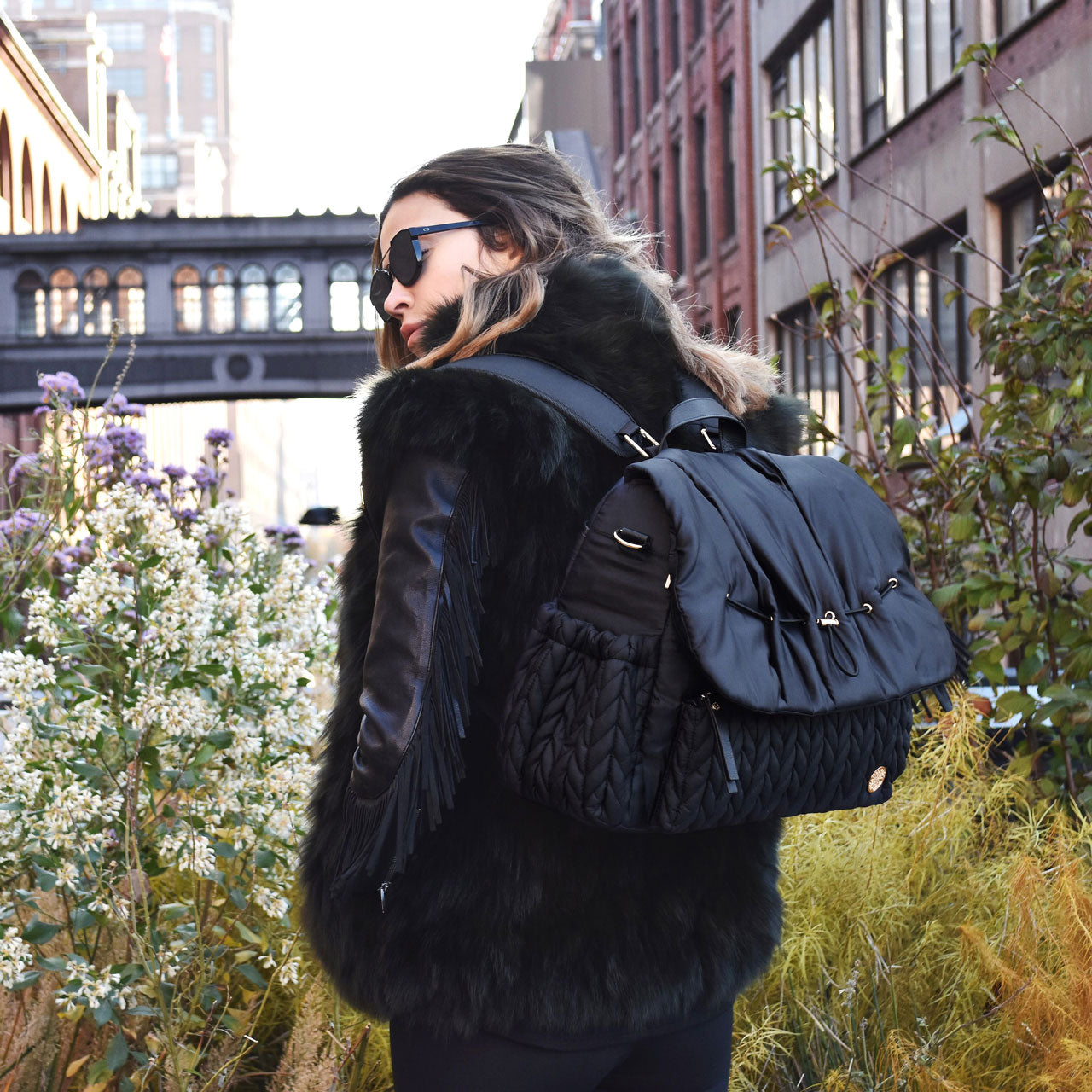 A chic mom in NYC wears all black with her HAPP Levy Backpack in Black with the wide padded straps on both shoulders.