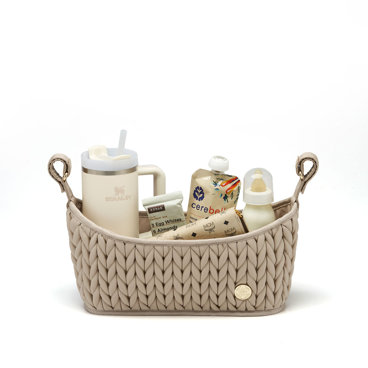 Fully packed Beige stroller organizer standing upright on a white background. Shows herringbone quilting detail, gold hardware, and adjustable grippy straps.