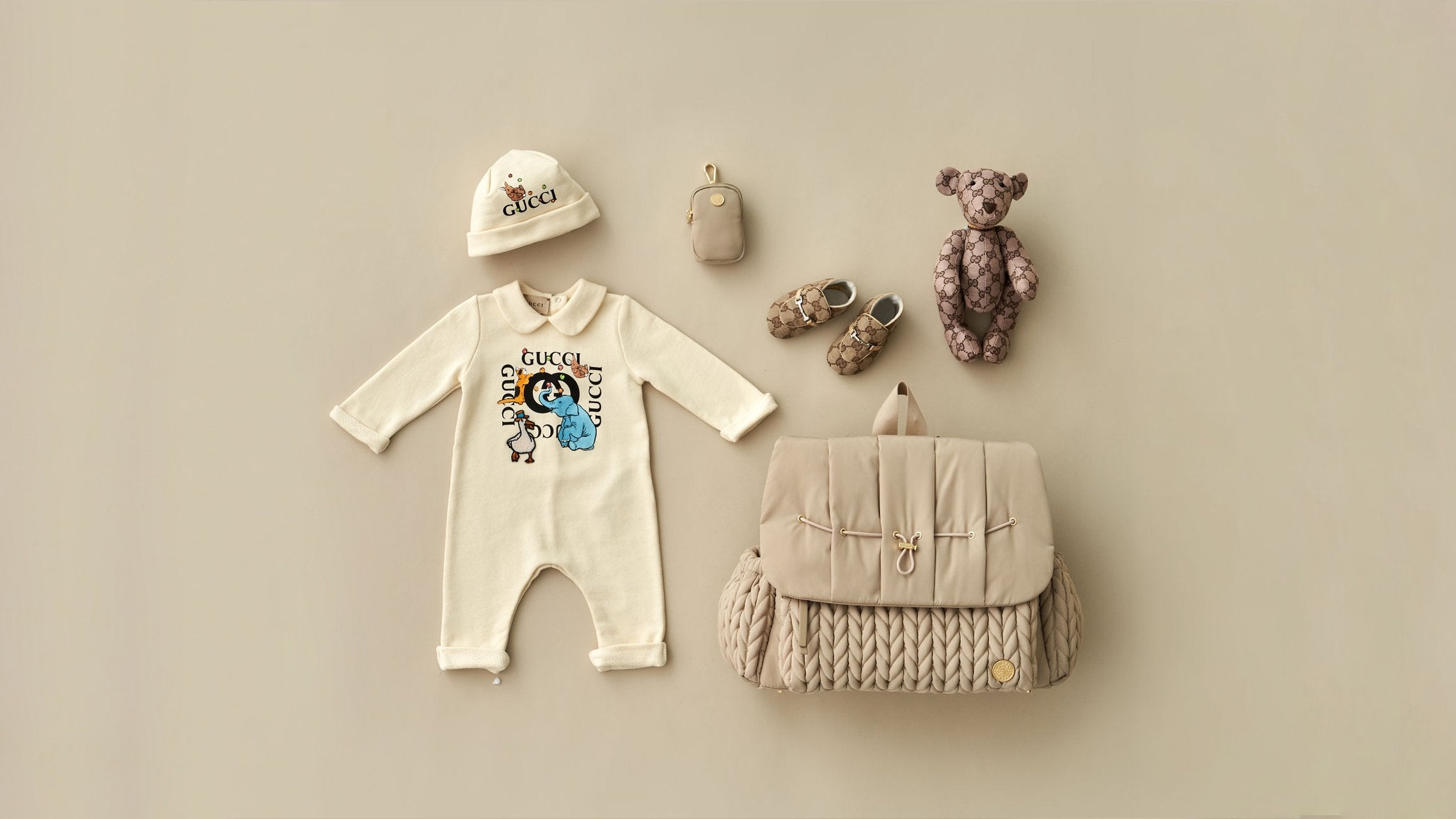 HAPP Brand Levy Backpack in Beige with matching clip-on pouch and coordinated baby items arranged on a beige background.