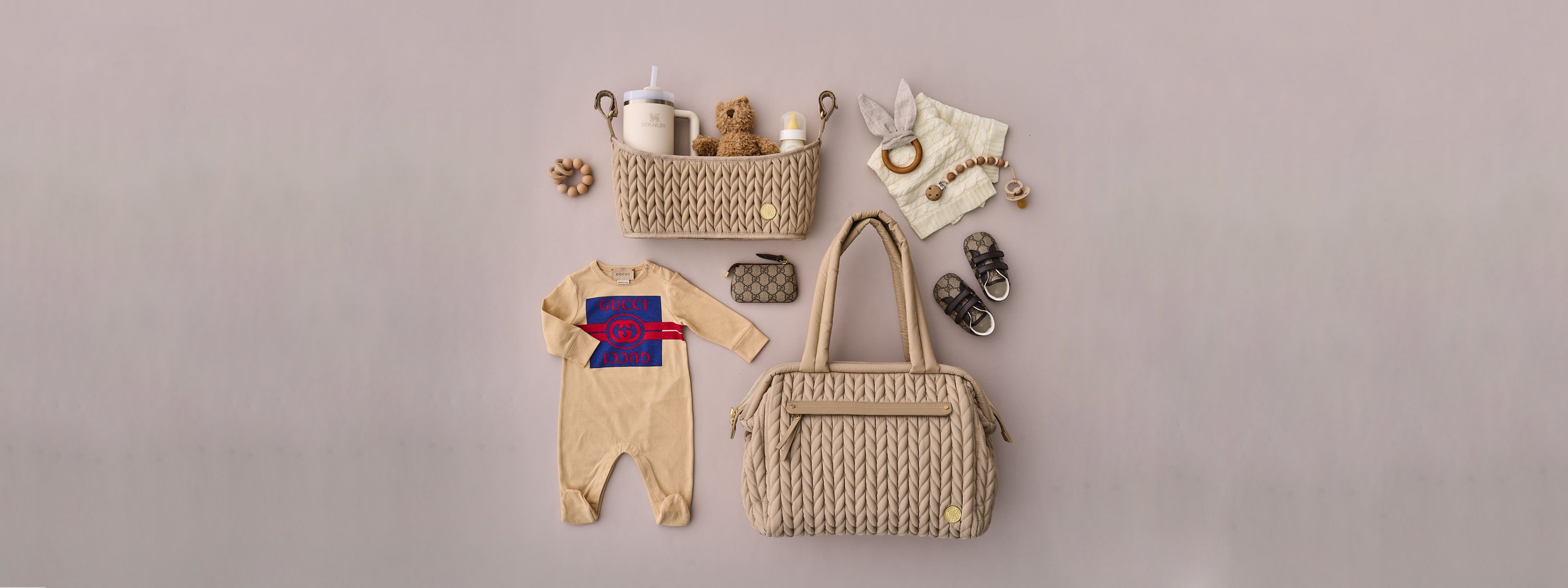 Paige Carryall Beige and Stroller Organizer Beige in a flat lay image with matching baby items on a beige background.