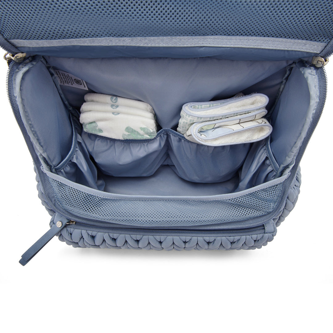 Levy Backpack Ash Blue shown open from the top down to show the spacious main compartment and 4 interior pockets for easy organization. Bag is lined with blue fabric.