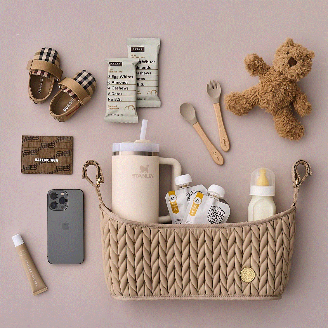 Moving GIF of the Stroller Organizer Beige shown with pink, beige, and blue backgrounds, each packed and arranged with matching mom and baby items according to each background color.