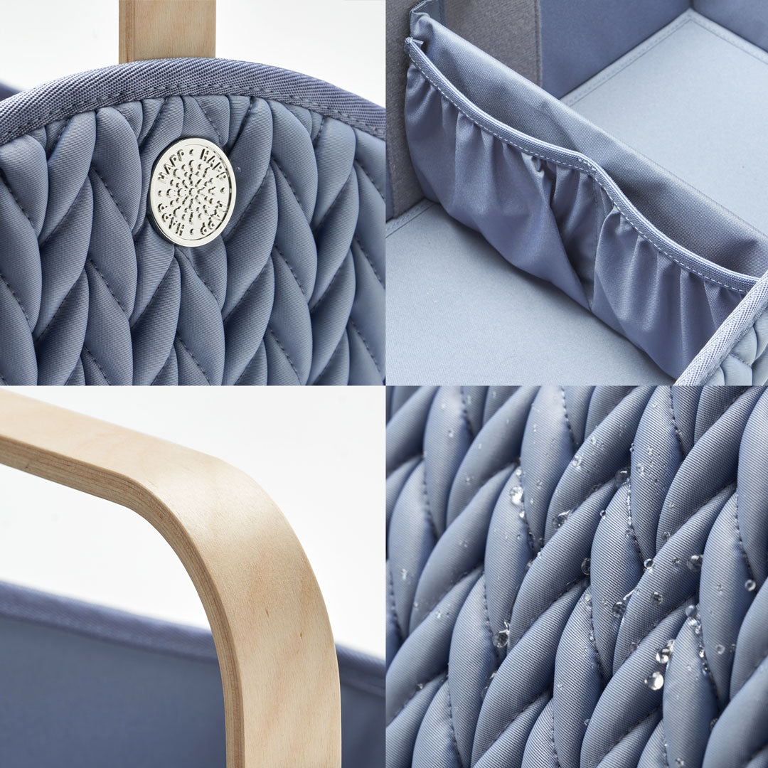 4-photo grid of Blue Diaper Caddy details; silver hardware on 3D herringbone, detachable pocket divider, sleek lightweight wooden handle, and water droplets on water-resistant wipeable fabric.