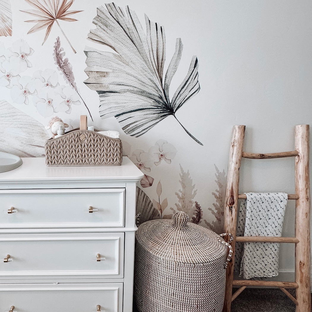Beige diaper caddy packed with matching baby items, shown on the white dresser in a neutral-themed nursery.