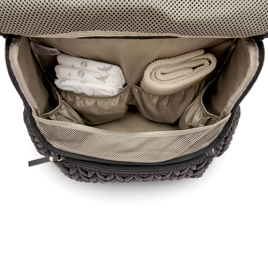 Levy Backpack Black shown open from the top down to show the spacious main compartment and 4 interior pockets for easy organization. Bag is lined with beige fabric.