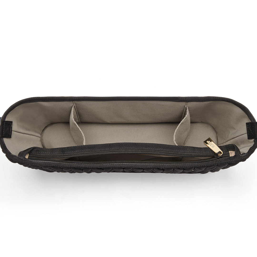 Top-down view of empty interior of black stroller organizer. Lining is beige, with 3 main compartments and one separate zippered compartment. Gold hardware.