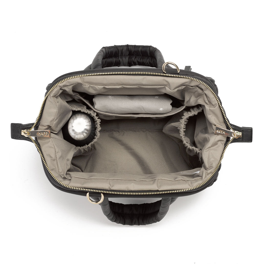 Top-down photo of open Paige Mini Black, showing the wide Mary Poppins opening with 2 of the 3 pockets packed with baby items.