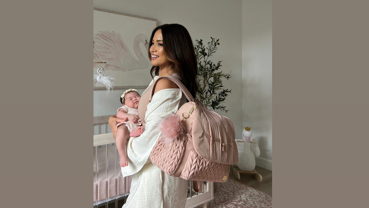 Jessi Malay carrying the Levy Backpack diaper bag in Dusty Rose.