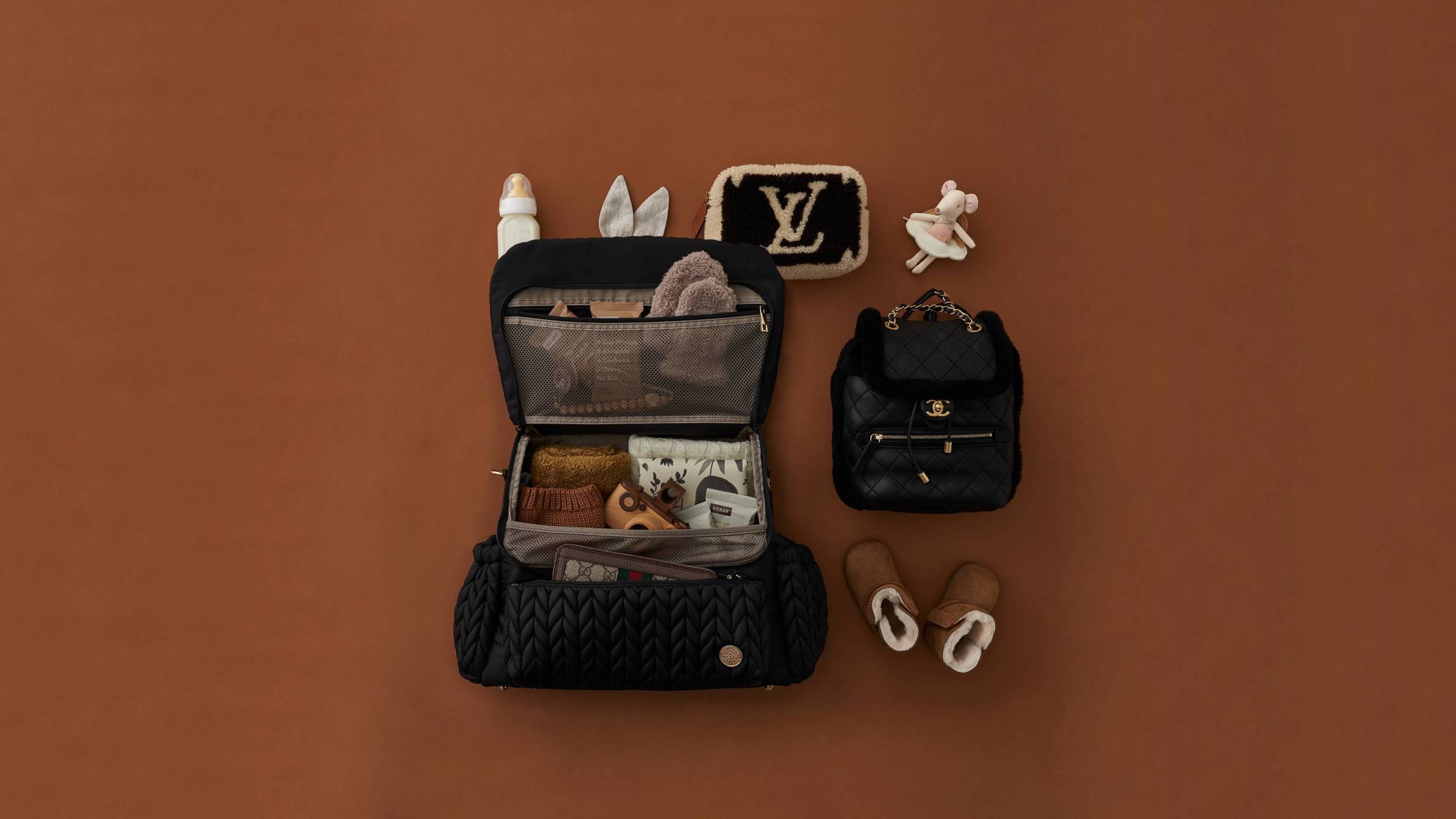 HAPP Brand Levy Backpack in Black shown open to display excellent interior organization, in a flat-lay image styled with chic matching accessories.