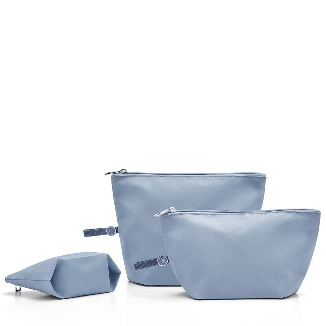 Set of three blue expandable packing pouches of different sizes with zipper closures and pull-tab loops, displayed against a white background.